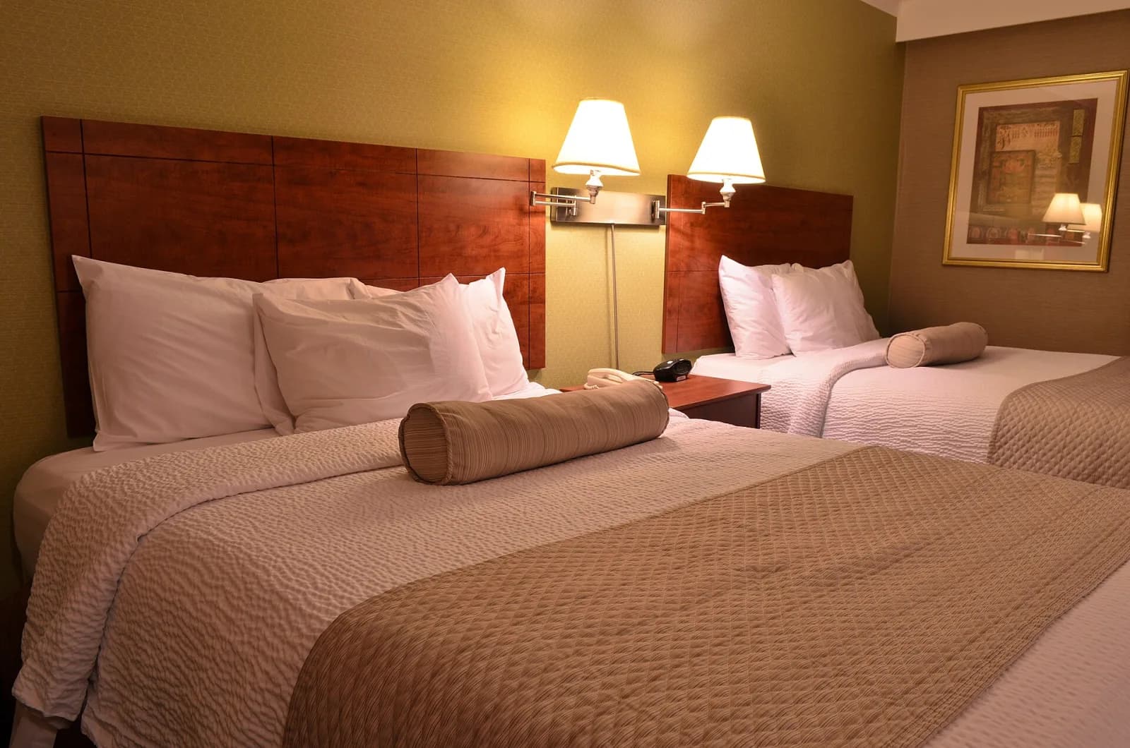 İki yataklı, sıcak ışıklı bir otel odası